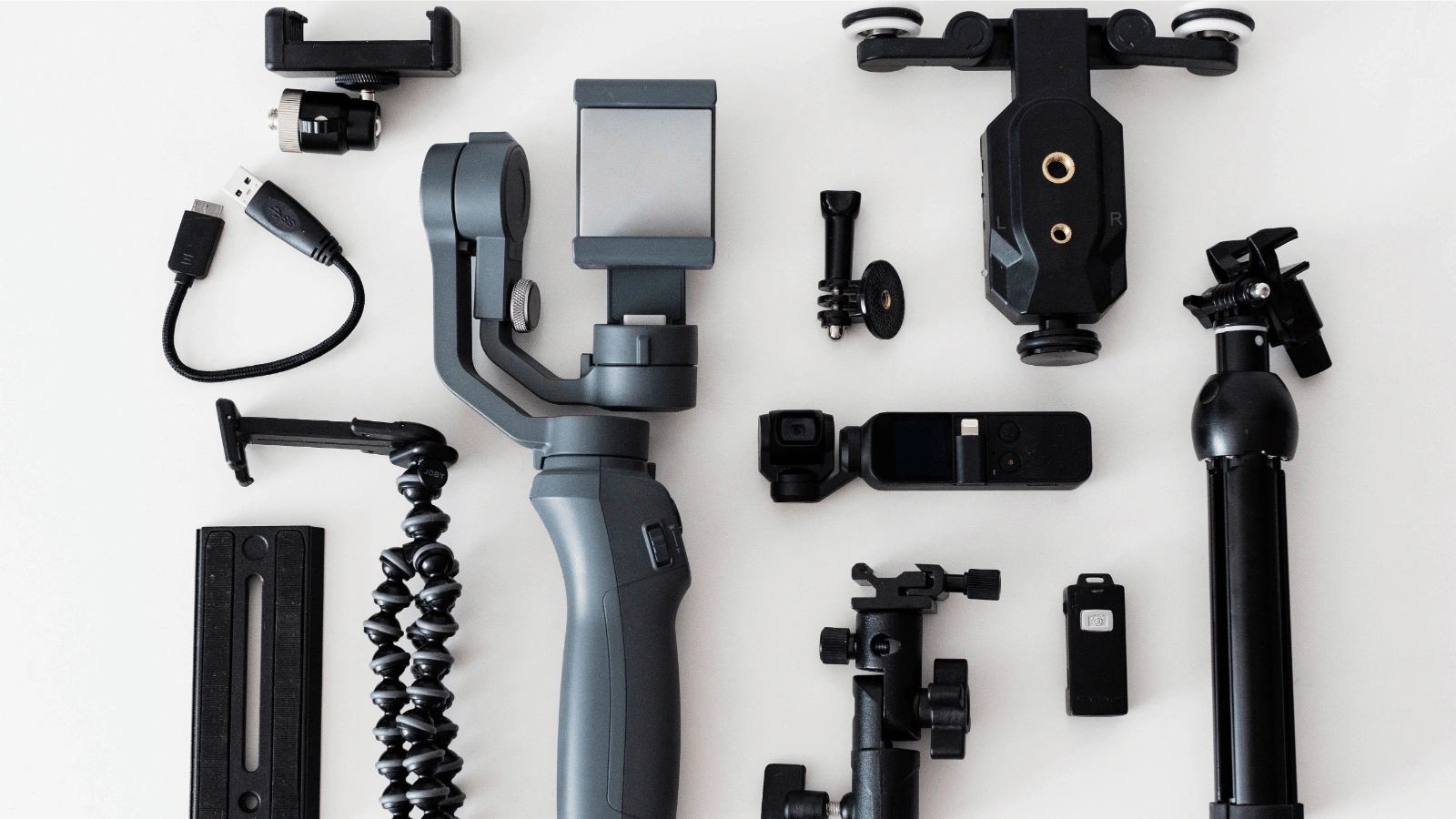 Collection of camera accessories like gimbal and mounts ideal for action shots for sporting goods on a white surface.