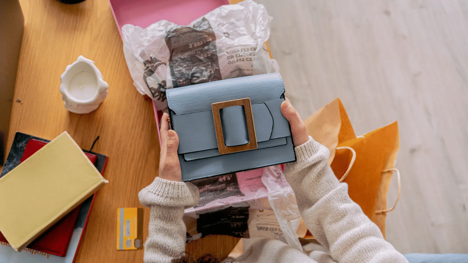  Ecommerce product videos display a person unboxing a stylish blue handbag from a package.