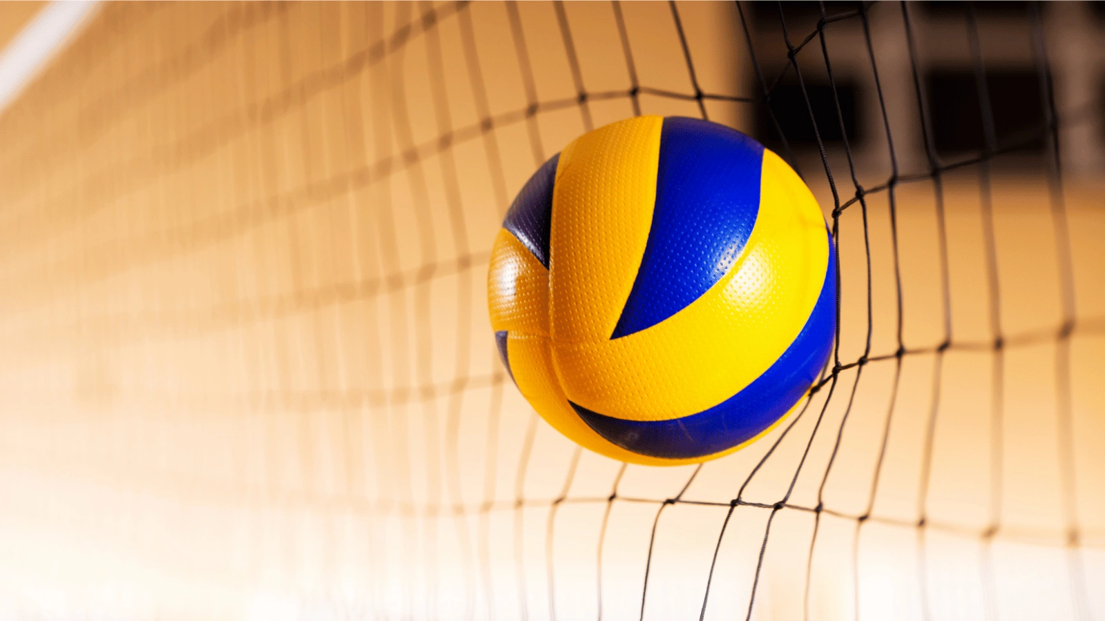 Volleyball hitting the net during an intense game perfect for action shots for sporting goods in a dynamic setting.
